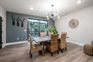 Dining space with wood-type flooring and a chandelier