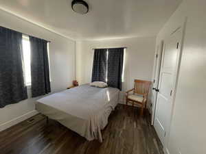 Bedroom with dark wood-type flooring