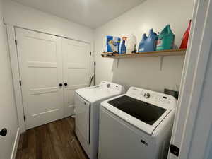 Washroom featuring washing machine and clothes dryer and dark wood-type flooring