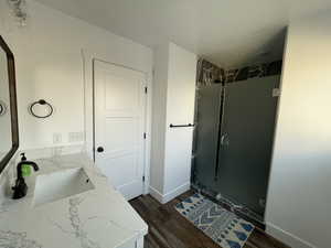 Bathroom featuring vanity, hardwood / wood-style floors, and tiled shower