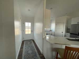 Entryway with vaulted ceiling and dark hardwood / wood-style flooring