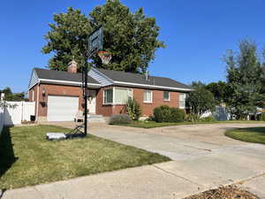 Single story home featuring a garage and a front lawn