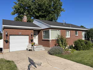 Ranch-style house featuring a garage and a front lawn