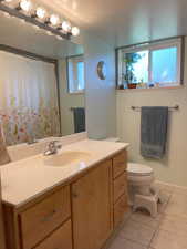 Bathroom featuring tile patterned flooring, vanity, and toilet