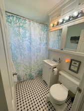 Bathroom with vanity, toilet, and curtained shower