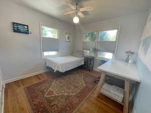 Bedroom with ceiling fan and hardwood / wood-style flooring