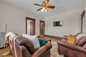 Living room featuring light hardwood / wood-style floors, radiator, and ceiling fan