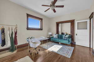 Office area with ceiling fan and dark wood-type flooring