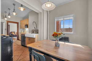 Dining room with ornamental molding, light tile patterned floors, and sink