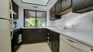 Kitchen with dark brown cabinets and Beige appliances