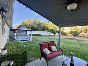 View of yard featuring ceiling fan, a gazebo, a hot tub, and a wooden deck