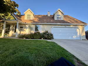 Two Story Cape cod home with a front yard and a garage