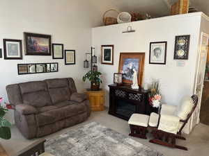 Carpeted living room with high vaulted ceiling