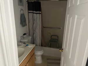 Full bathroom featuring vanity, toilet, shower / bathtub combination with curtain, and tile patterned floors