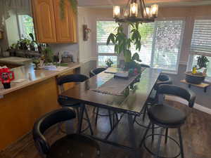 Dining room with a chandelier, sink, and dark hardwood / wood-style flooring