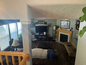 Living room with wood-type flooring and a tile fireplace