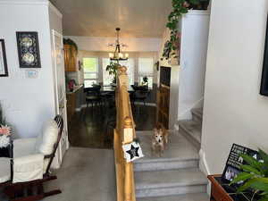 Stairway featuring a notable chandelier, ornamental molding, and hardwood / wood-style floors