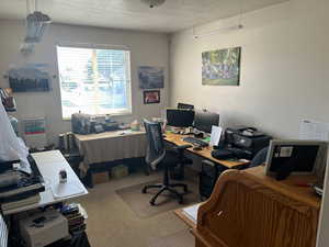 Office space with a textured ceiling and carpet flooring