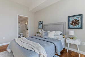 Bedroom featuring connected bathroom and dark hardwood / wood-style flooring