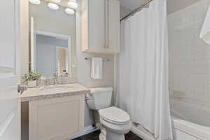 Full bathroom with tile patterned flooring, shower / bath combo, vanity, and toilet