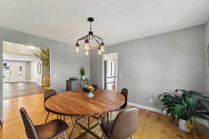 Dining room with an inviting chandelier and hardwood / wood-style floors