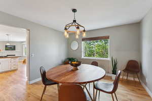 Dining space featuring a fireplace, light hardwood / wood-style flooring, and a chandelier