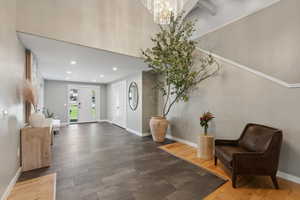 Entrance foyer featuring dark wood-type flooring and a notable chandelier