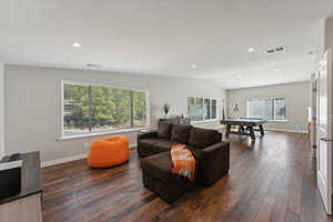 Living room with lofted ceiling and dark hardwood / wood-style flooring