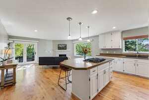 Kitchen featuring white cabinets, a wealth of natural light, sink, and stainless steel gas cooktop