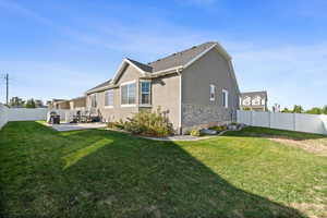 Back of property with a lawn and a patio area