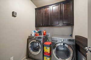 Laundry area with washer and dryer and cabinets