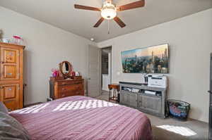 Carpeted bedroom featuring ceiling fan