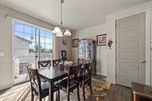 Dining area featuring wood-type flooring and an inviting chandelier