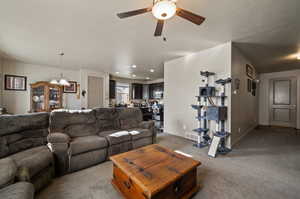 Carpeted living room featuring ceiling fan