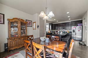 Dining space featuring dark wood-type flooring and a chandelier