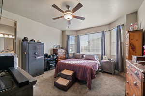 Carpeted bedroom with a textured ceiling and ceiling fan