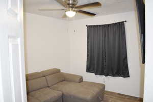 Sitting room with a textured ceiling, hardwood / wood-style floors, and ceiling fan