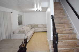 Living room featuring a textured ceiling and hardwood / wood-style floors