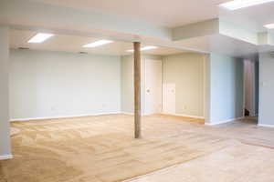 Basement featuring light colored carpet