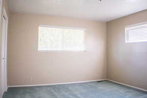 Carpeted spare room featuring a textured ceiling