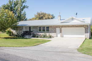 Single story home featuring a garage and a front lawn