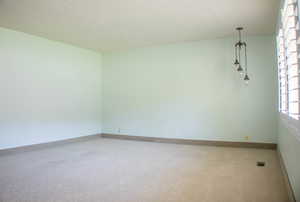 Spare room featuring a textured ceiling and carpet flooring