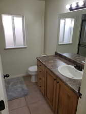 Bathroom featuring vanity, toilet, and tile patterned floors