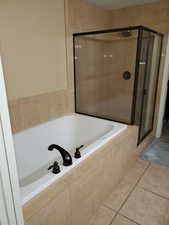 Bathroom featuring independent shower and bath and tile patterned flooring