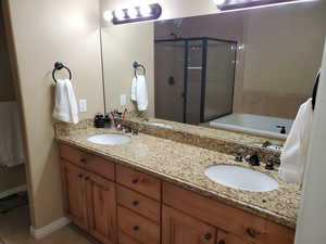 Bathroom featuring vanity, shower with separate bathtub, and tile patterned floors