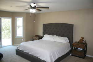 Bedroom featuring access to outside, carpet flooring, and ceiling fan