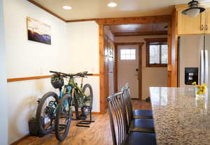 Dining space featuring light hardwood / wood-style flooring, ceiling fan, beamed ceiling, and crown molding