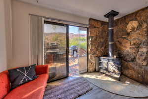 Living room with a mountain view, hardwood / wood-style flooring, and a wood stove