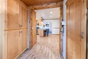 Hall featuring ornamental molding and light hardwood / wood-style floors