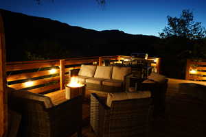 Patio terrace at dusk with an outdoor hangout area and a deck with mountain view